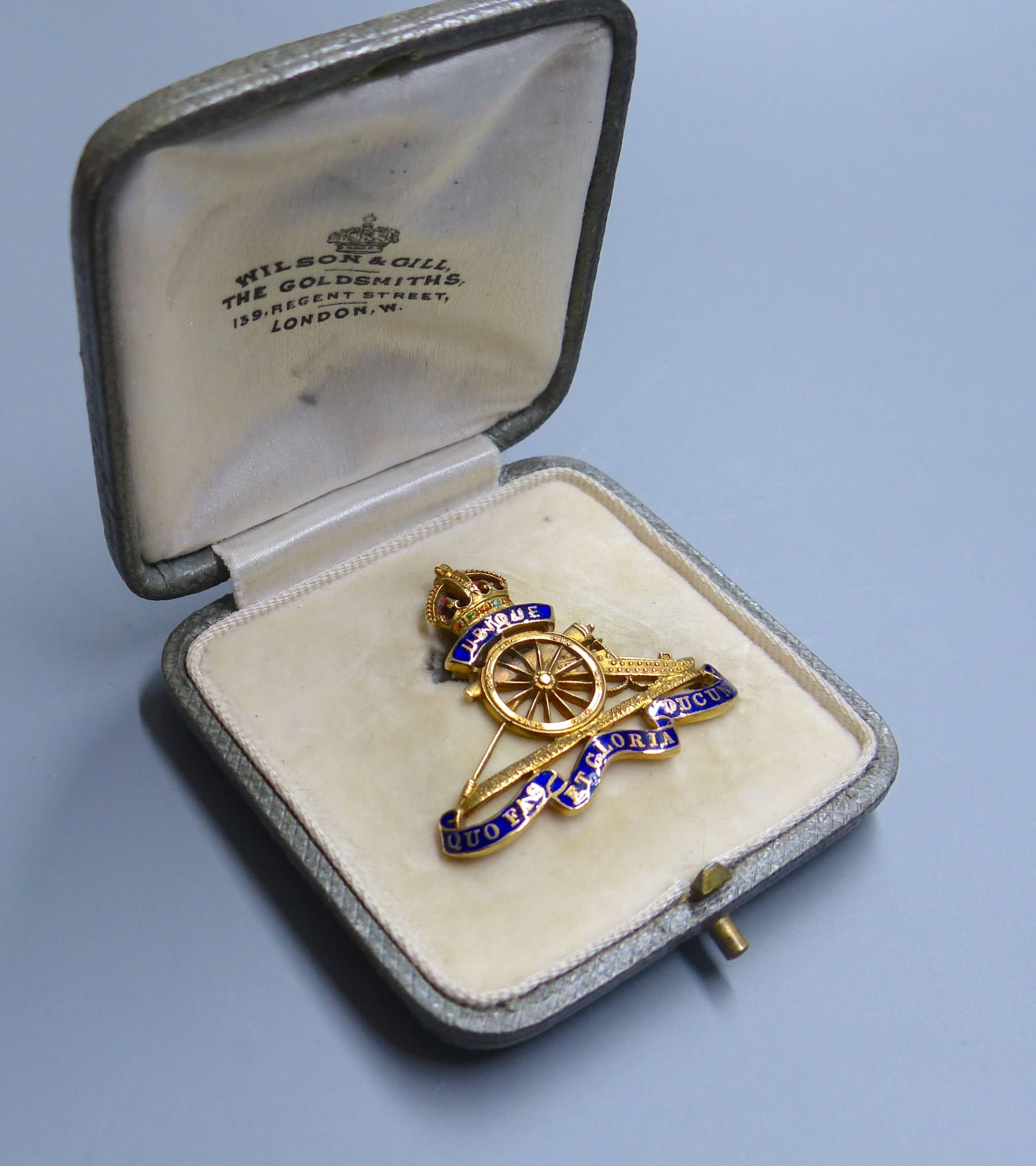 A cased early 20th century 15ct and four colour enamel Royal Artillery sweethearts brooch, width 34mm, gross 6.3 grams.